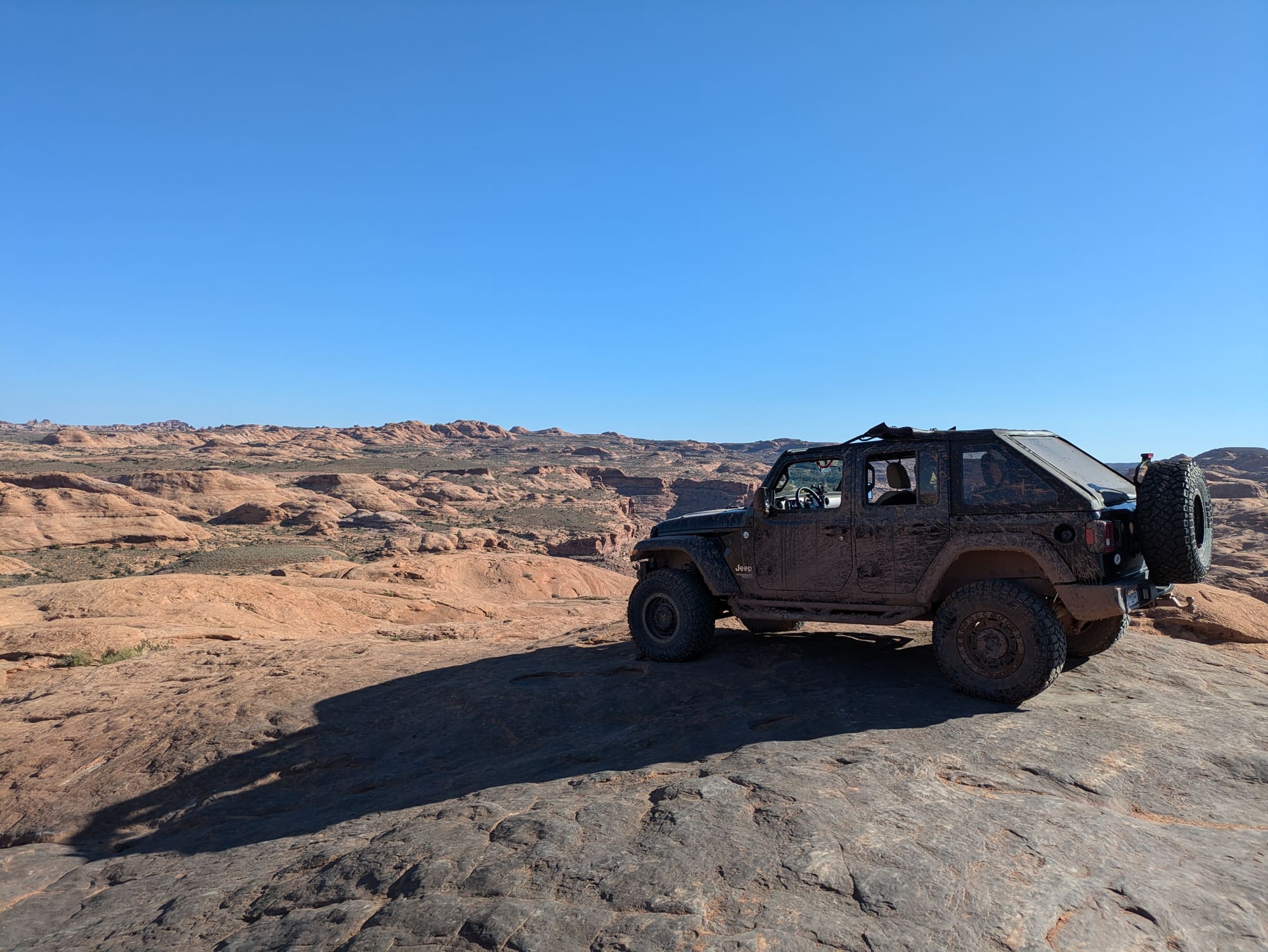 Sucia the Jeep parked on a slickrock rim above the Colorado River near Moab